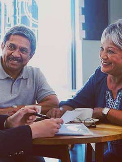 Smiling elderly couple consulting with legal team