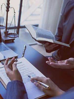 Legal team discussion while consulting books and paperwork