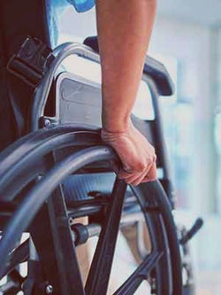 Close up of a person's hand moving a wheelchair